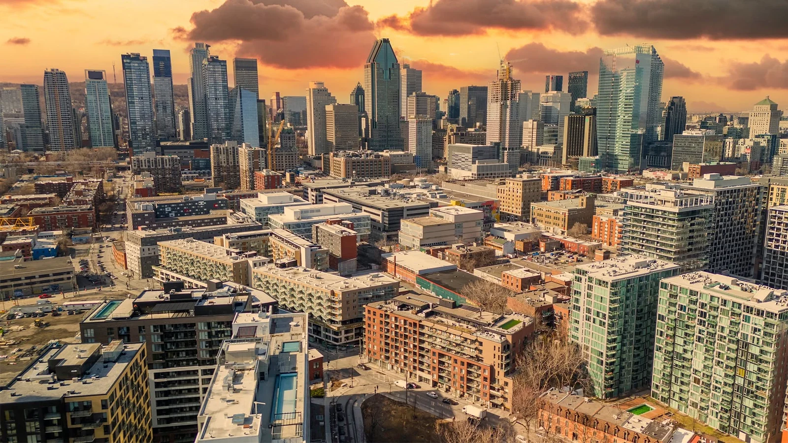 Vue en hauteur d’immeubles et de gratte-ciel sous un ciel orangé