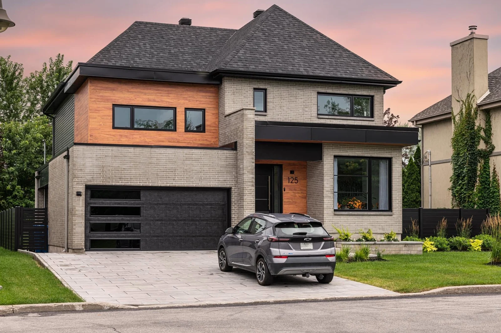 Façade de maison contemporaine en brique et bois avec une voiture dans l’entrée
